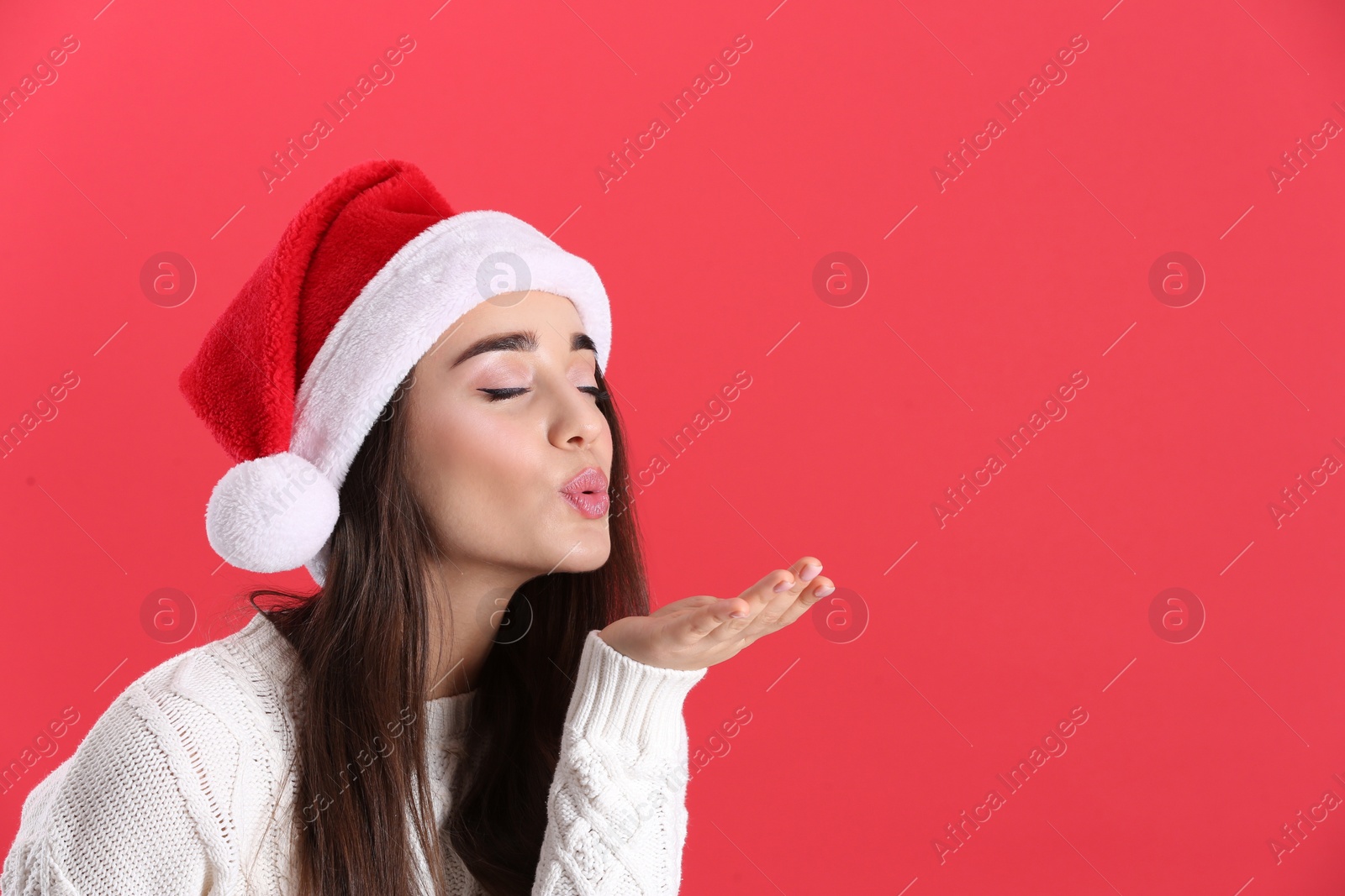 Photo of Beautiful woman wearing Santa Claus hat on red background. Space for text