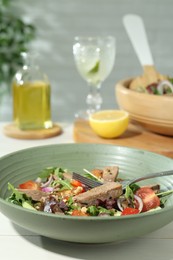 Photo of Delicious salad with beef tongue, vegetables and fork served on white wooden table