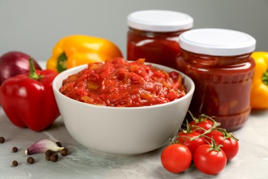 Photo of Delicious lecho and fresh ingredients on light grey marble table, closeup