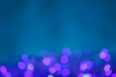 Photo of Blurred violet Christmas lights against blue background