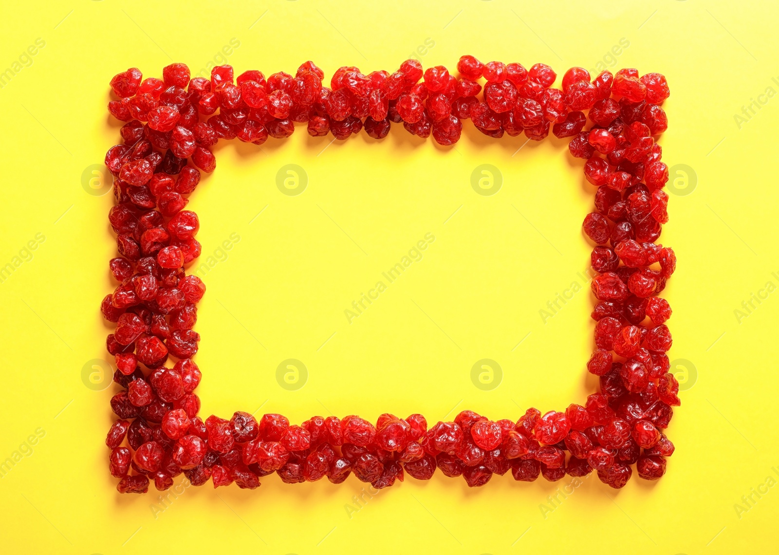 Photo of Frame made of cherries on color background, top view with space for text. Dried fruits as healthy food
