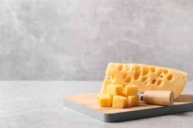 Tasty fresh cheese with fork on grey table, space for text