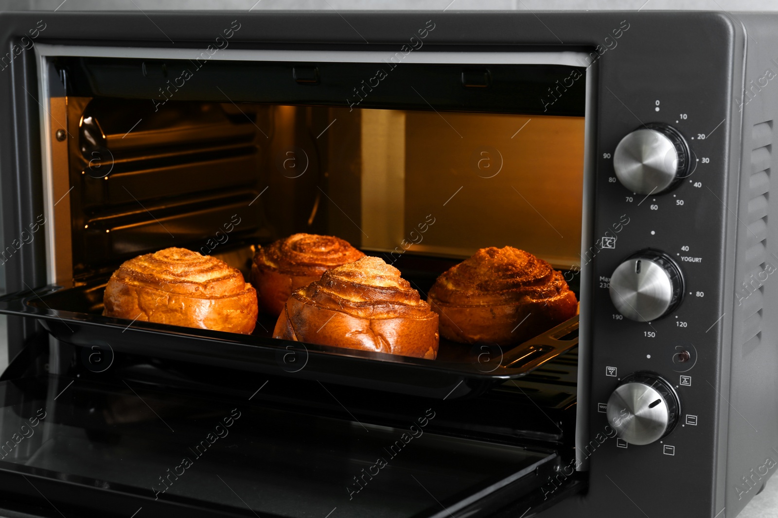 Photo of Open electric oven with delicious sweet pastry