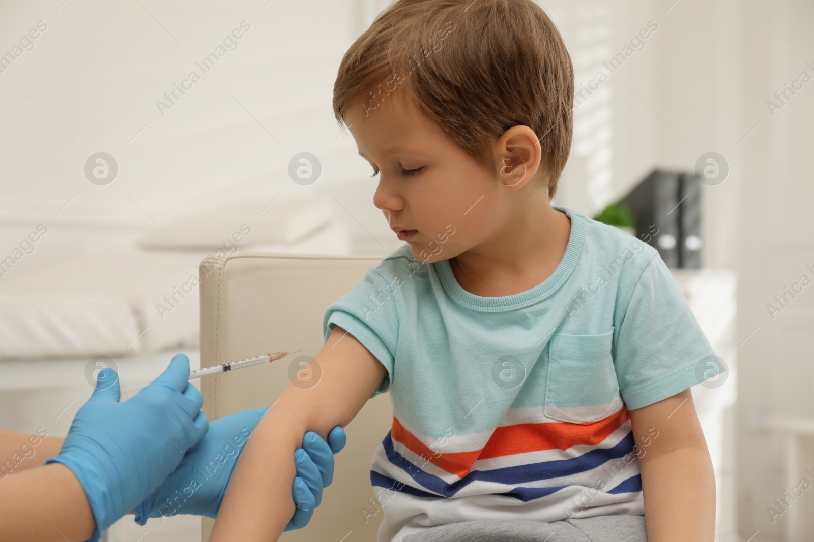 Photo of Nurse vaccinating little boy in clinic. Immunization concept