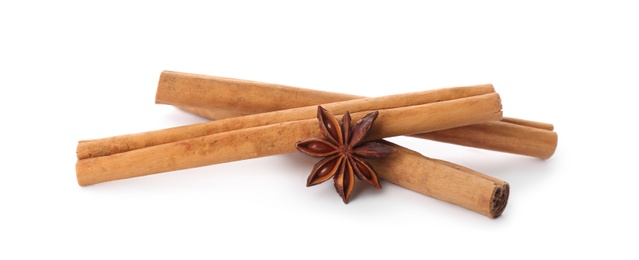 Photo of Aromatic cinnamon sticks and anise isolated on white