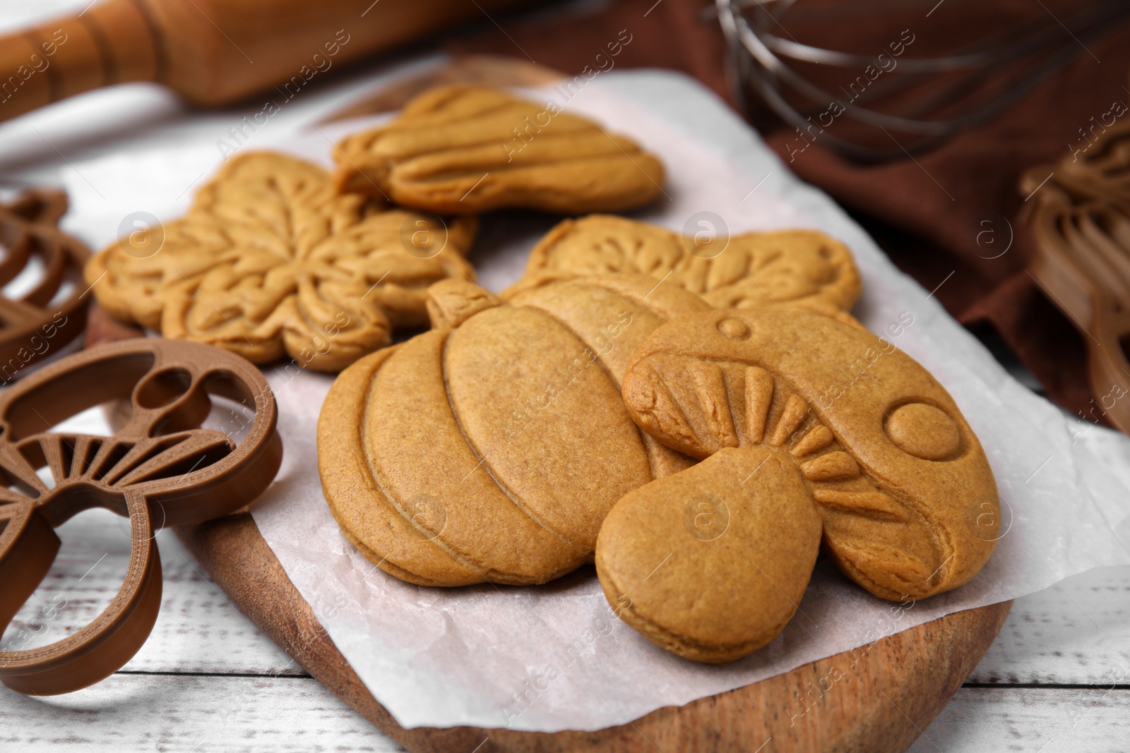 Photo of Tasty cookies and cutters on white wooden table, closeup