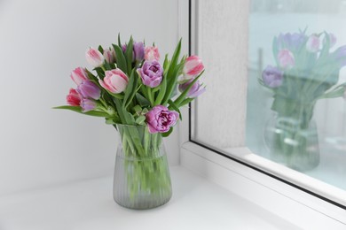 Beautiful bouquet of colorful tulip flowers on windowsill indoors, space for text