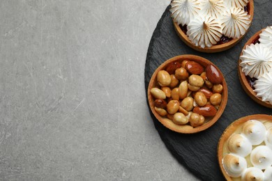 Different tartlets on grey table, top view and space for text. Delicious dessert