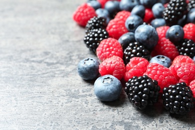 Photo of Raspberries, blackberries and blueberries on table