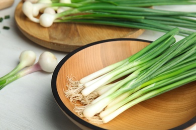 Photo of Plate with fresh green onion on table, closeup