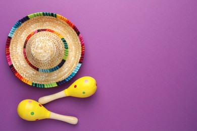 Photo of Mexican sombrero hat and maracas on purple background, flat lay. Space for text