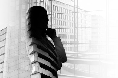 Double exposure of businesswoman and cityscape with office buildings
