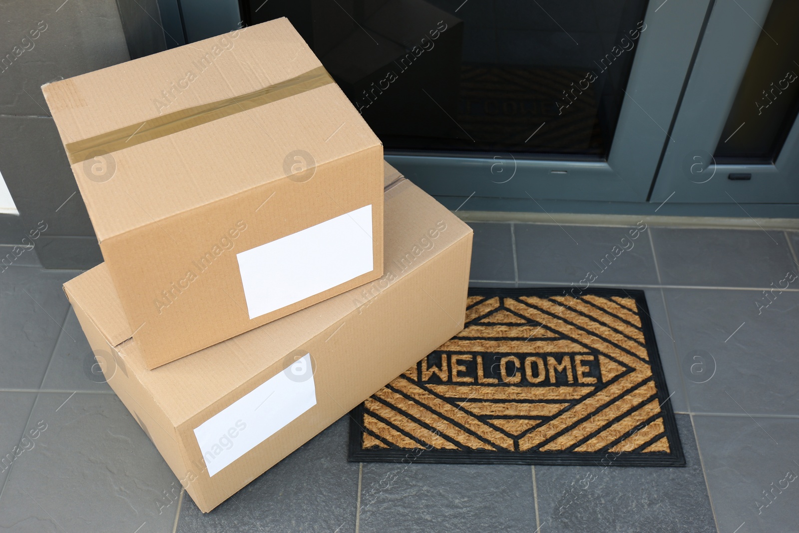 Photo of Cardboard boxes near door. Parcel delivery service