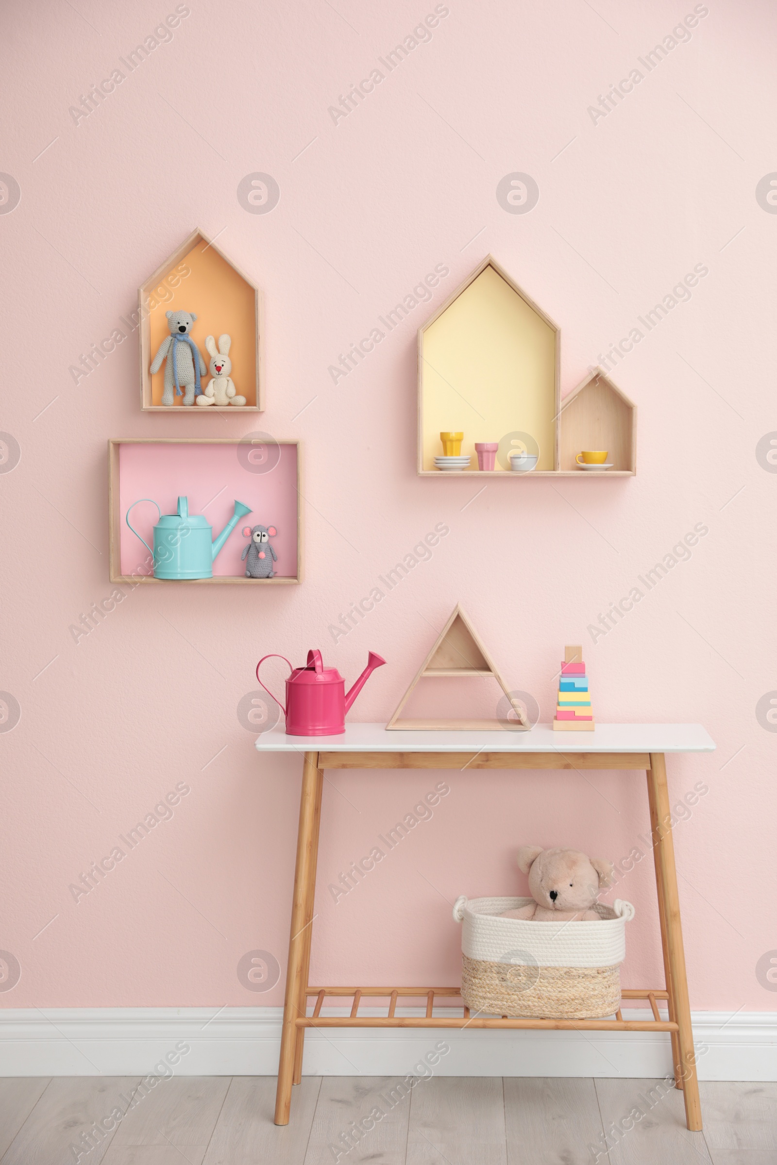 Photo of Stylish baby room interior design with house shaped shelves and wooden table