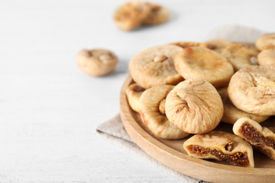 Tasty dried figs on white wooden table, closeup