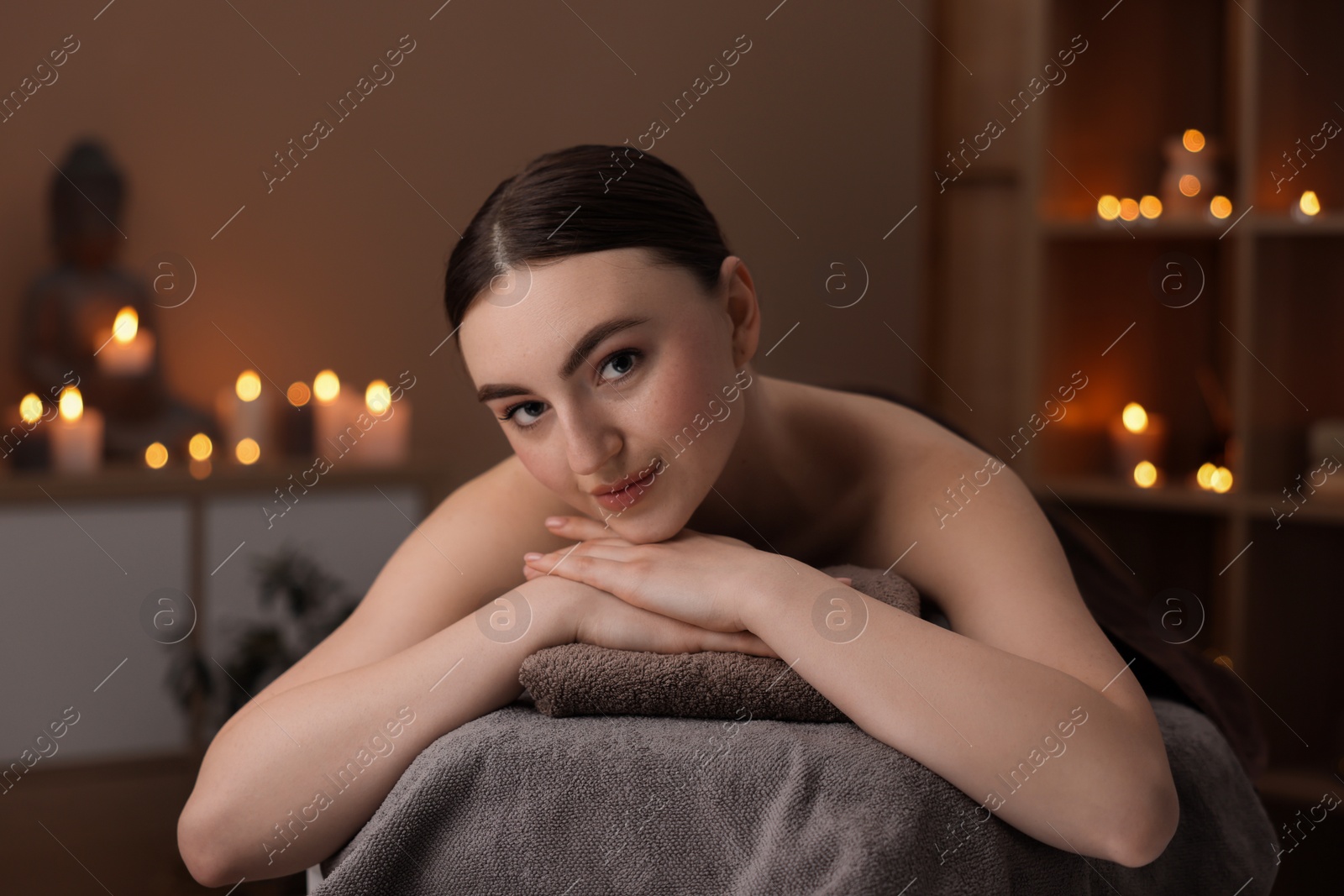 Photo of Spa therapy. Beautiful young woman lying on massage table in salon