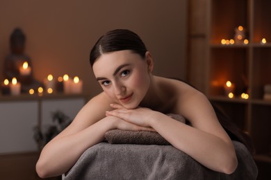 Photo of Spa therapy. Beautiful young woman lying on massage table in salon