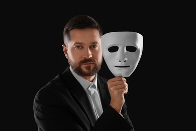 Photo of Multiple personality concept. Man with mask on black background