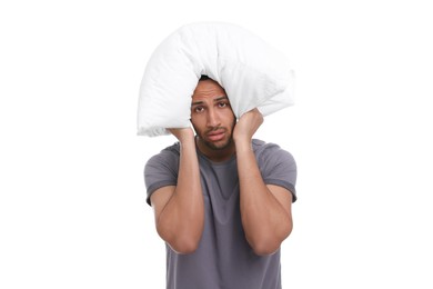 Photo of Tired man covering ears with pillow on white background. Insomnia problem
