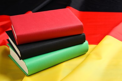 Photo of Learning foreign language. Different books on flag of Germany