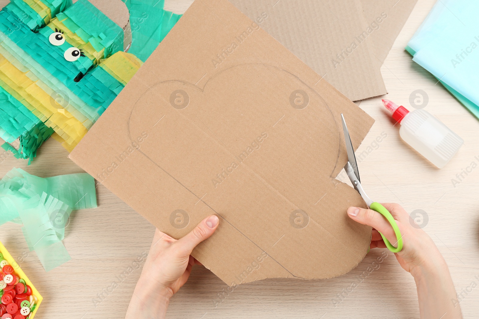 Photo of Woman making cardboard cloud at wooden table, top view. Pinata diy