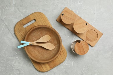 Wooden cooking utensils on grey marble table, flat lay
