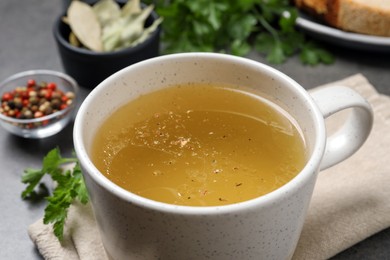 Photo of Hot delicious bouillon in cup on table, closeup