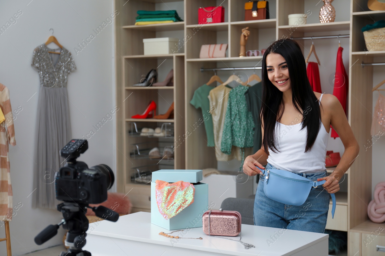 Photo of Fashion blogger recording new video at table indoors