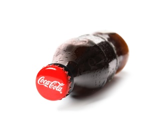 MYKOLAIV, UKRAINE - NOVEMBER 15, 2018: Glass bottle of Coca Cola on white background, focus on cap