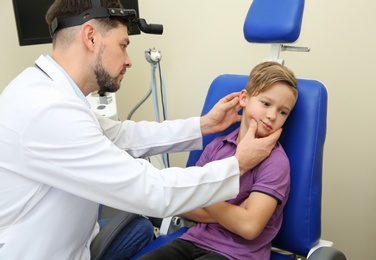 Male otolaryngologist examining little child in hospital