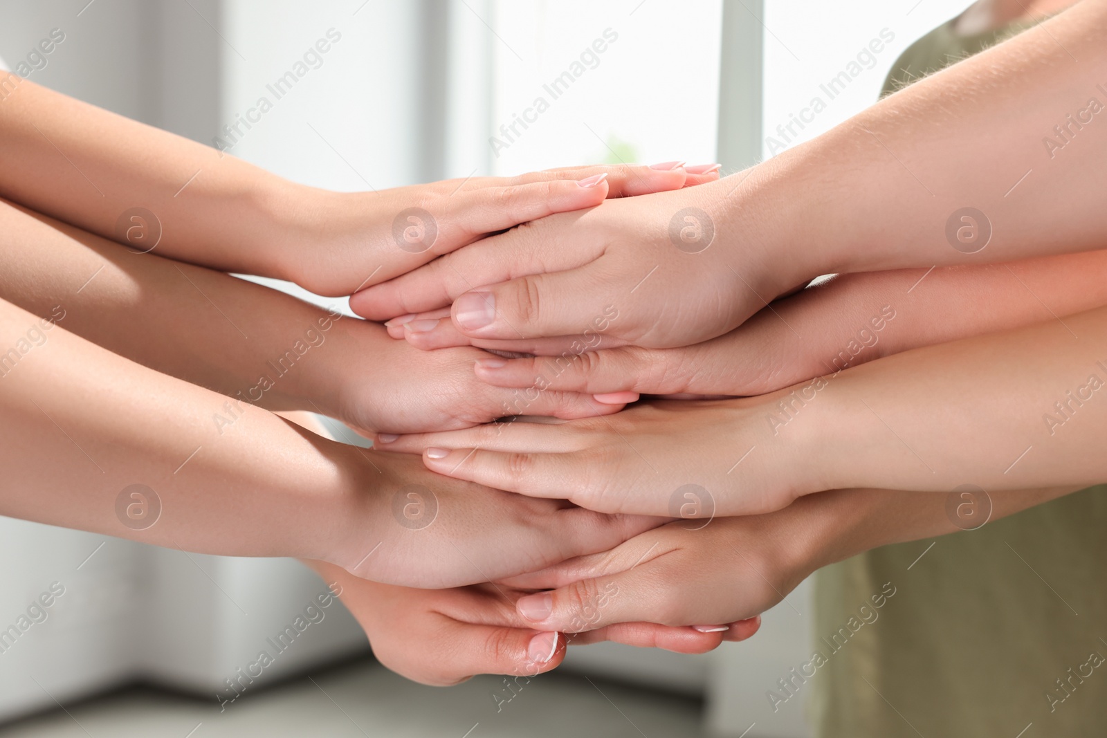 Photo of Group of people holding hands together indoors, closeup. Unity concept