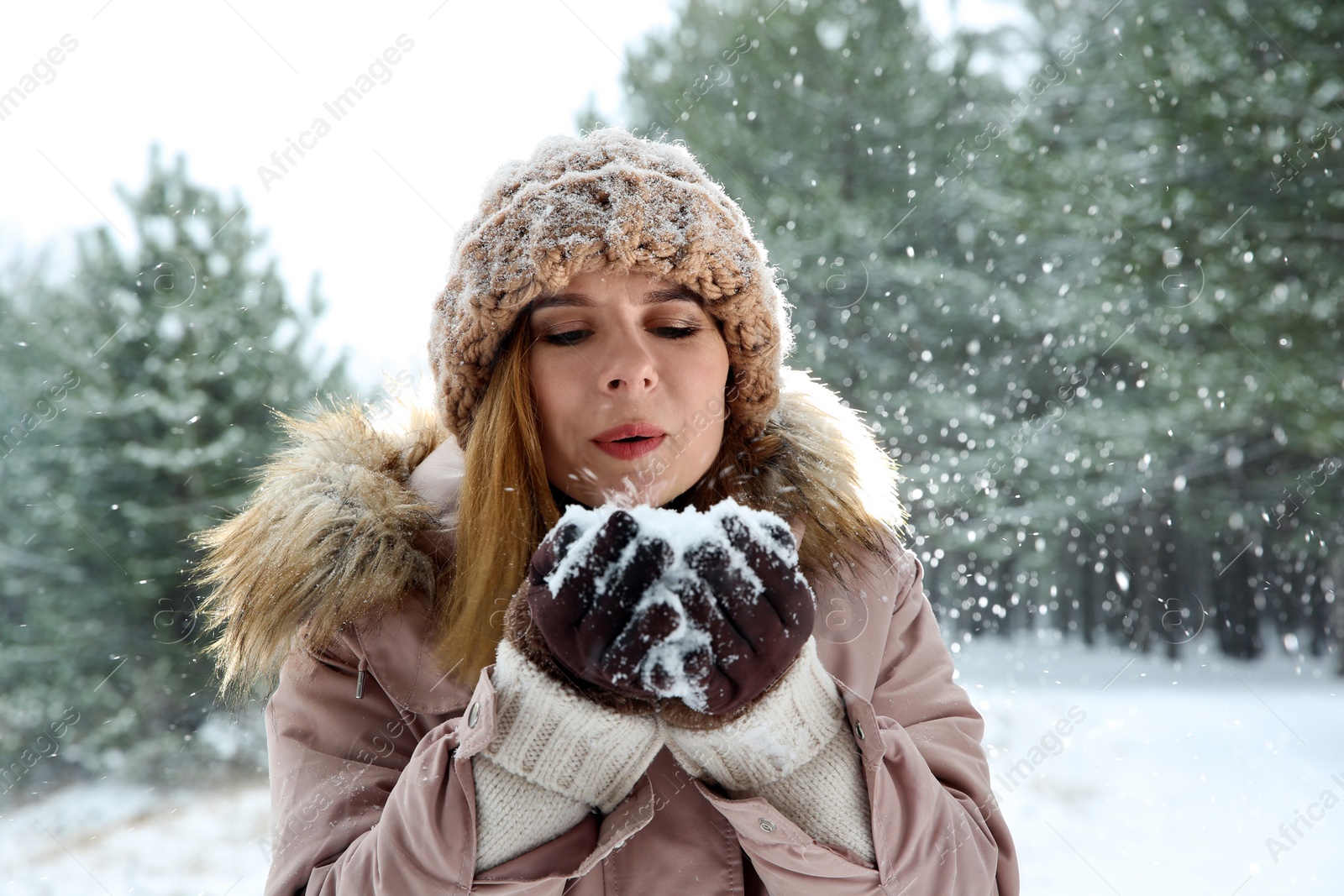 Photo of Beautiful woman blowing snow in winter forest