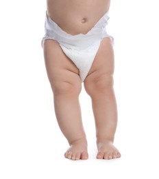 Photo of Cute baby in dry soft diaper standing on white background, closeup