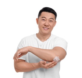 Photo of Handsome man applying body cream onto his elbow on white background