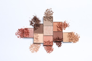 Crushed eye shadows on white background, top view. Professional makeup product