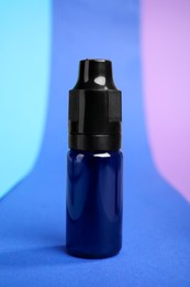 Photo of Bottle with blue food coloring on bright background