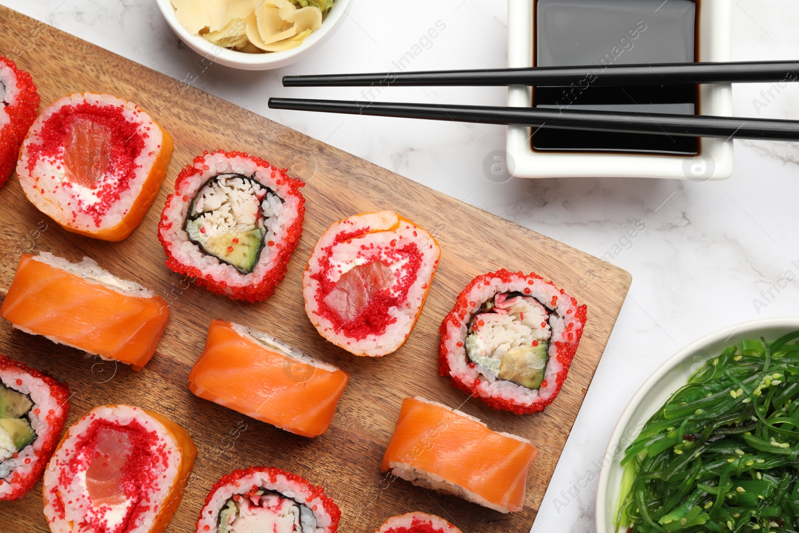 Photo of Flat lay composition with delicious sushi rolls on white marble table