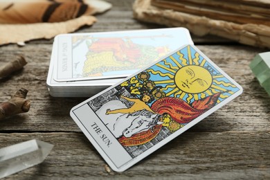 Sun and other tarot cards on wooden table, closeup