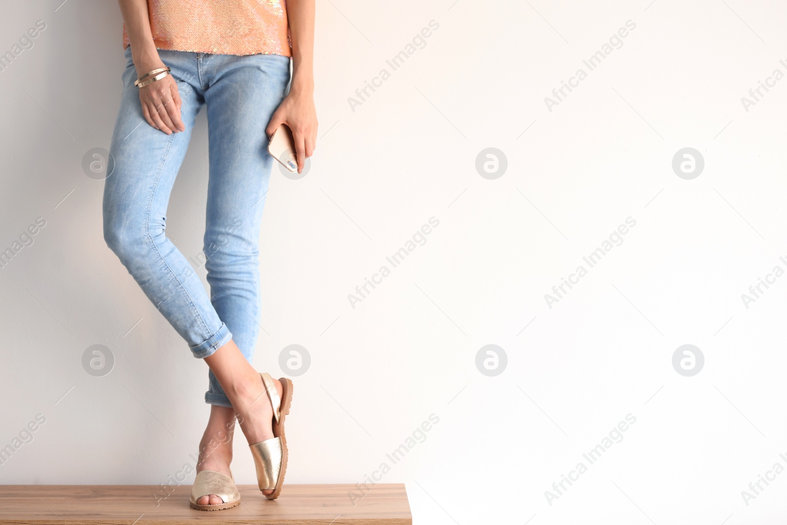 Photo of Young woman wearing elegant shoes on table, closeup