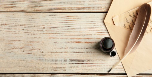 Quill, bottle of ink and letter on white wooden table, flat lay with space for text. Banner design