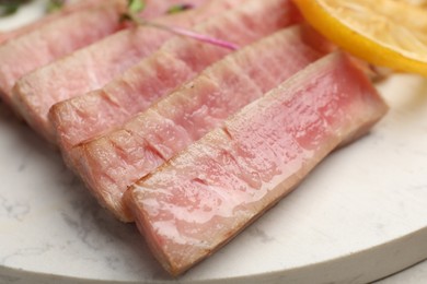 Photo of Pieces of delicious tuna steak on serving board, closeup