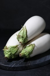 Fresh white eggplants on black table, closeup