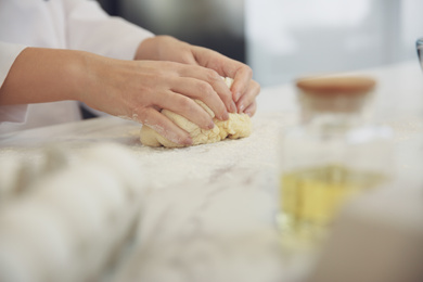 Chef cooking dough at table in kitchen, closeup