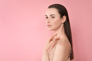 Photo of Portrait of beautiful young woman on pink background. Space for text