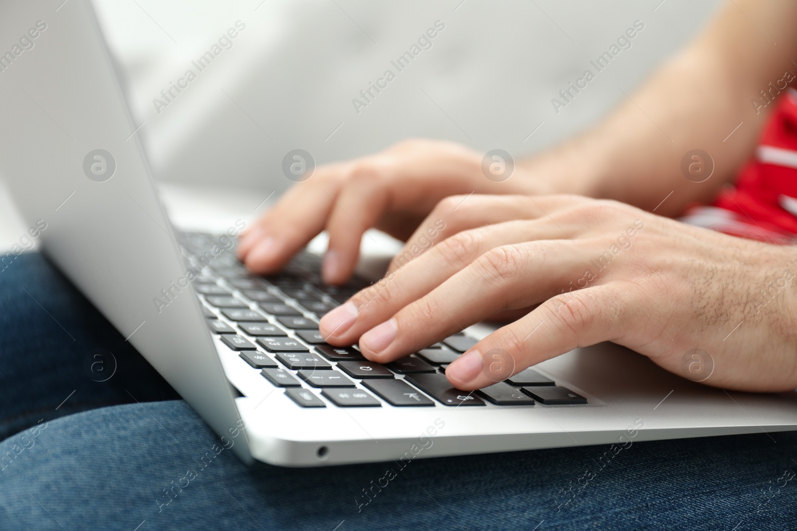 Photo of Man working on modern laptop at home, closeup