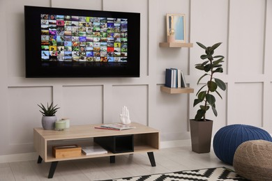 Stylish living room interior with modern TV on white wall