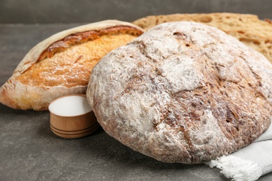 Photo of Different kinds of fresh bread on grey table, closeup