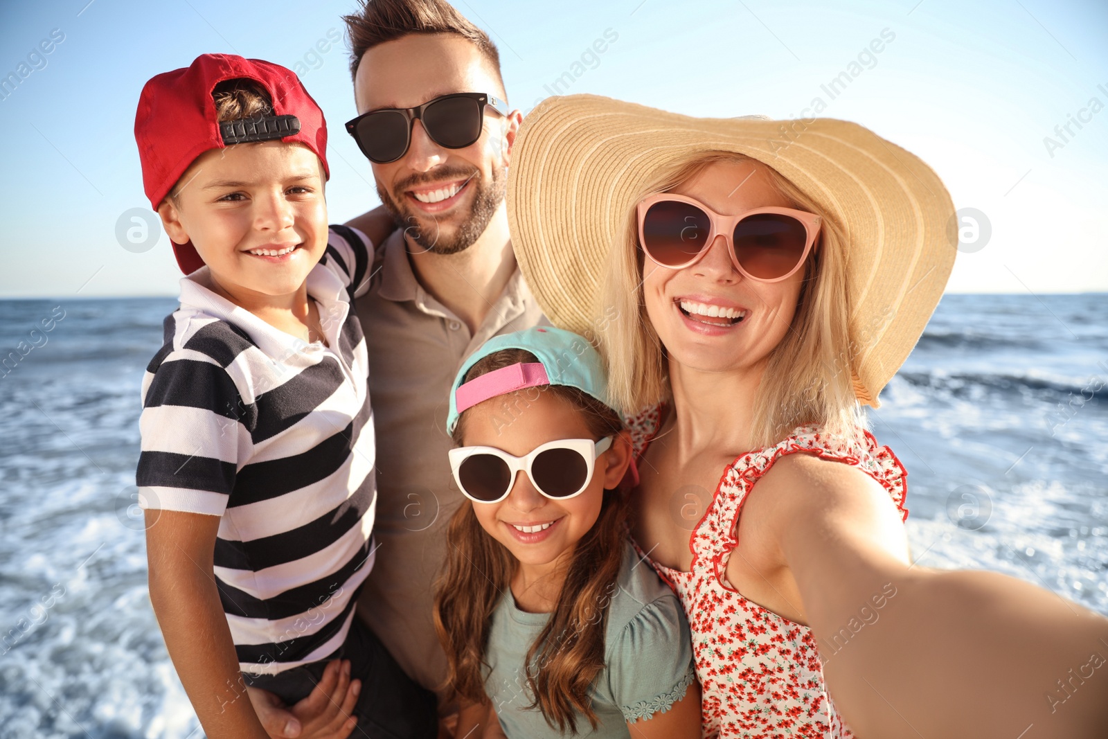 Photo of Happy family taking selfie on beach near sea. Summer vacation