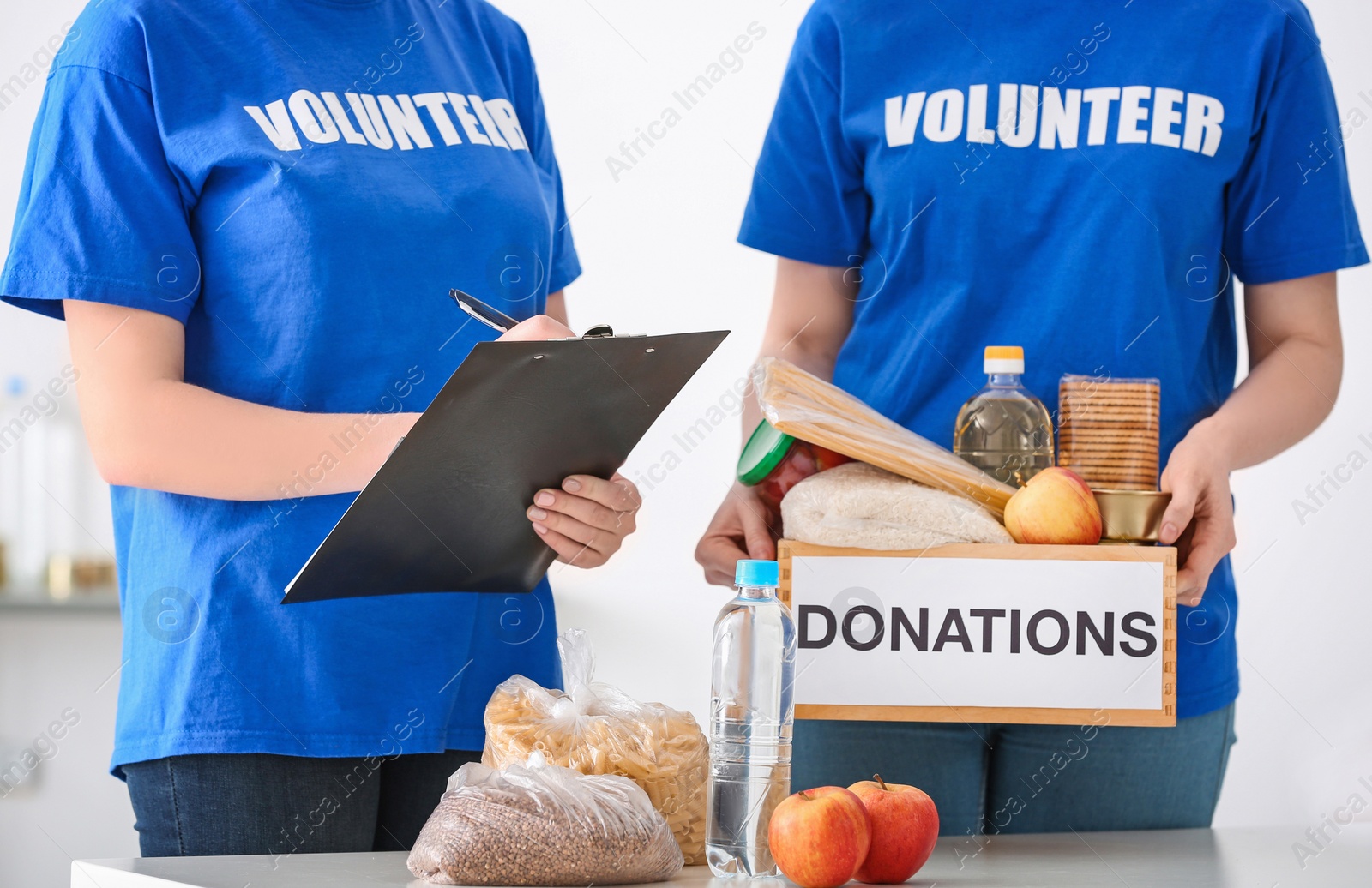 Photo of Volunteers with donation box and clipboard indoors