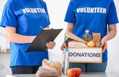 Volunteers with donation box and clipboard indoors